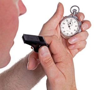 Referee checking stopwatch about to blow whistle