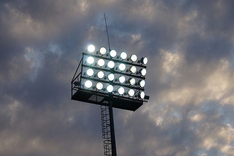 Football Stadium Floodlight Against Dark Cloudy Sky
