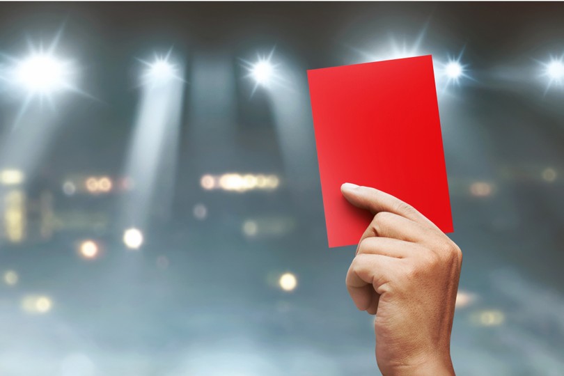 Football Red Card Held Against Stadium Lights