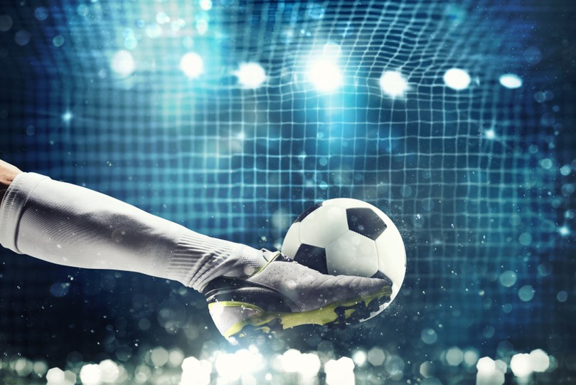 Footballer with White Boots Striking Ball at Goal